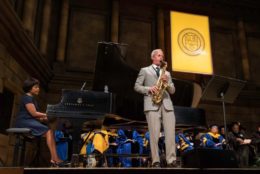 man in suit playing the saxophone on stage