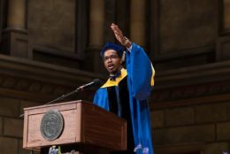 student speaking at podium in regalia during inauguration