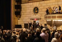 band coming out of doorway at the eastman theatre to a full house