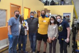 group of people posing for photo all wearing masks