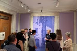 group listening in on museum discussion in front of art piece