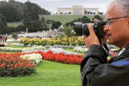 man taking photo with garden in background