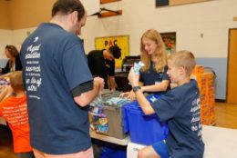 man and two kids working in bins in a gymnasium