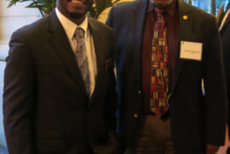 two men in a suit and tie smiling for a photo