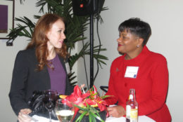 two women having a chat in front of a table having a drink