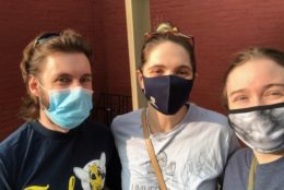 two women and a man wearing masks taking a selfie