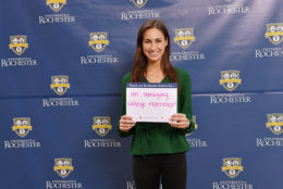 woman holding thank you card in front of UR backdrop