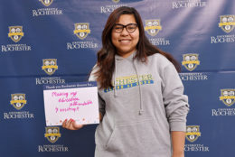 woman holding thank you card in front of UR backdrop