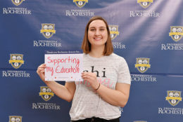 woman holding thank you card in front of UR backdrop