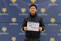 man holding thank you card in front of UR backdrop