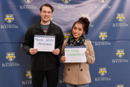 man and woman holding thank you card in front of UR backdrop