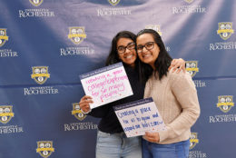 two women holding thank you card in front of UR backdrop