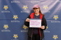 woman holding thank you card in front of UR backdrop