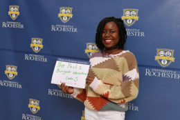 woman holding thank you card in front of UR backdrop