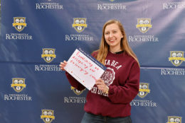 woman holding thank you card in front of UR backdrop