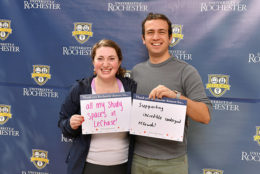 woman and man holding thank you card in front of UR backdrop