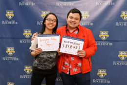 woman and man holding thank you card in front of UR backdrop