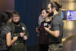 three women and one man in a circle speaking at an event