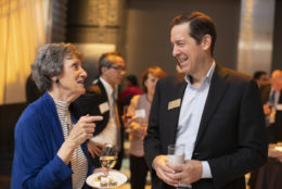 man facing a woman speaking both smiling