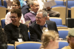 man and woman both wearing glasses seated with smiles on their faces