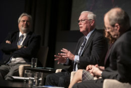 three men and a woman on stage during an event