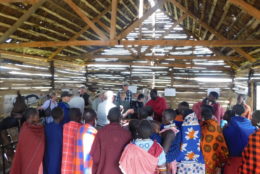 group of UR alumni in a building along with group of tanzanians