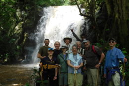 group of UR alumni posing for photo in front of waterfall