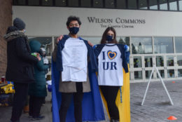 two people holding up their i heart UR tshirts and posing for photo wearing masks