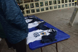 table outside building with several piles of i heart UR tshirts