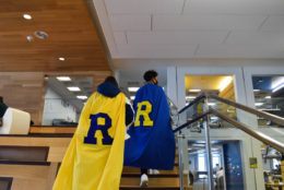 two people with large caps and an R on the back walking up stairs