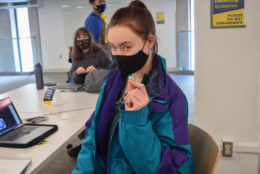 woman in black mask holding a i heart ur pin