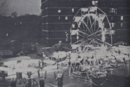 old black and white photo of ferris wheel and carnival rides in quad
