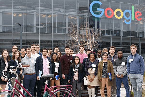 Group of people standing in front of Google building smiling and posing for camera