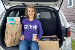 woman smiling wearing purple eastman sweatshirt sitting in back of car