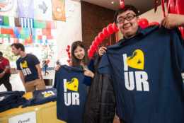 two people holding up dark blue i heart UR tshirts