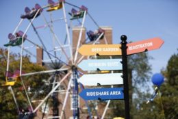 ferris wheel in background with direction street signs in foreground