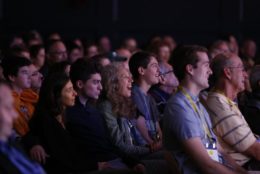 crowd in a darkened auditorium watching a talk or performance