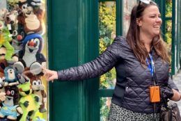 women smiling and pointing to stuffed animals in window of a store