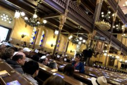 indoors with rows of wooden seating