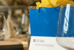 bag for alumni yellow tissue out the top and a wine glass in the corner