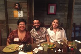 two women and one man at dinner table posing for photo
