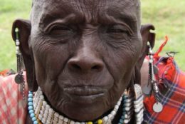 older tanzanian with bald head and green field in background