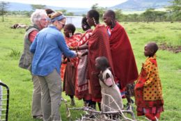 group of women tanzanians, with two children greeting two women