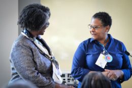 two women looking at each other smiling during event