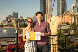 man and woman posing for photo with city harbor in background