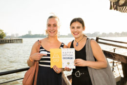 two women posing for photo with harbor in background