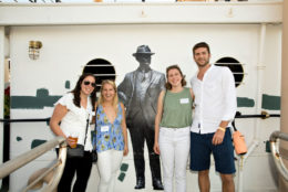 three women one man posing with george eastman cutout