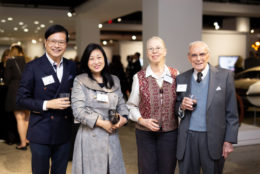 two men and two women posing for photo with drinks in hand