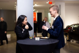 a man and woman facing each other in conversation while having drinks