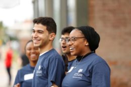 four smiling helpers wearing blue alumni t-shirts